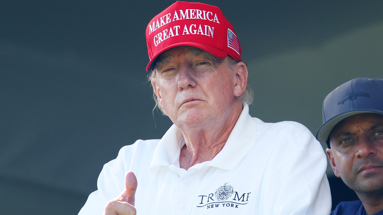 Donald Trump golf shirt and hat thumbs up