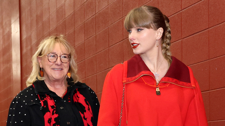 Donna Kelce smiling wearing red and black and Taylor swift wearing red.