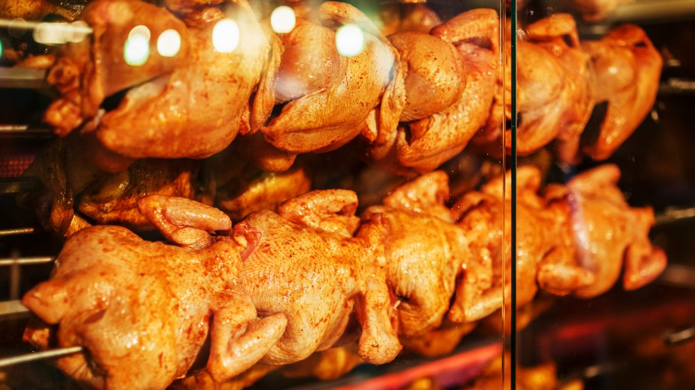 Rotisserie chickens cooking in an oven