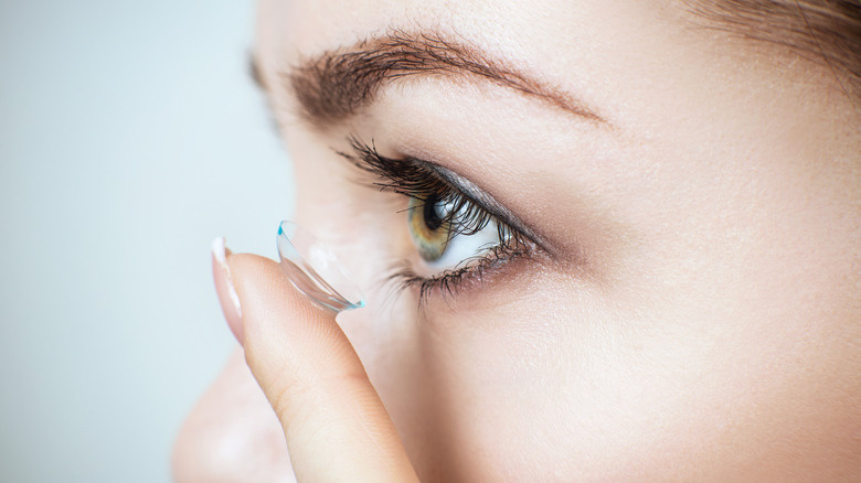 woman inserting a contact lens