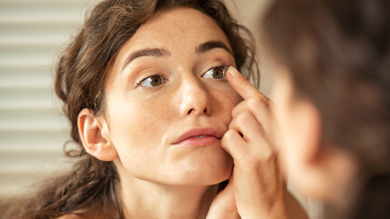 woman putting in contact lens