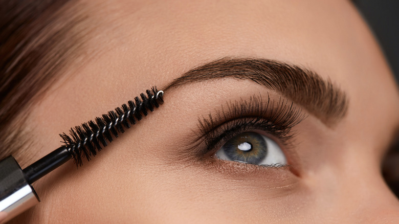 woman brushing eyebrow