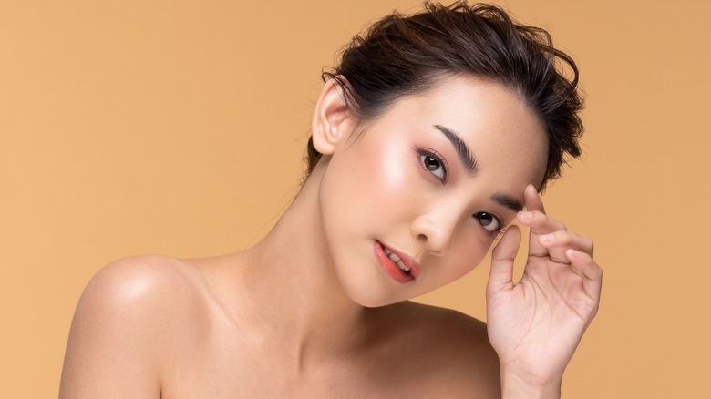 woman touching eyebrow