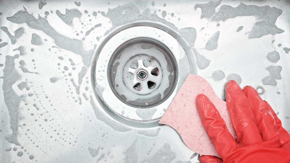 Woman's hand cleaning sink