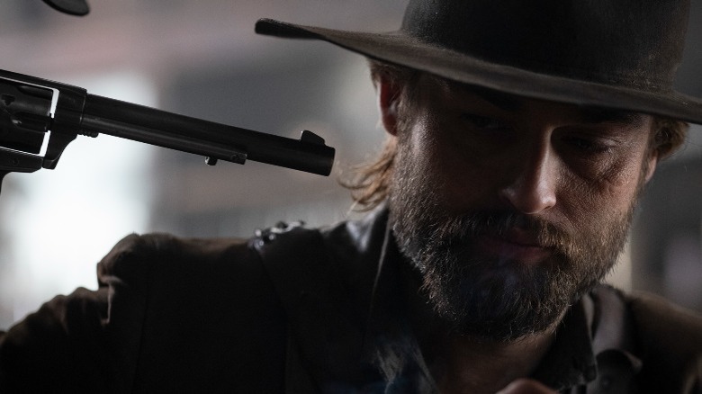 Douglas Booth with a gun
