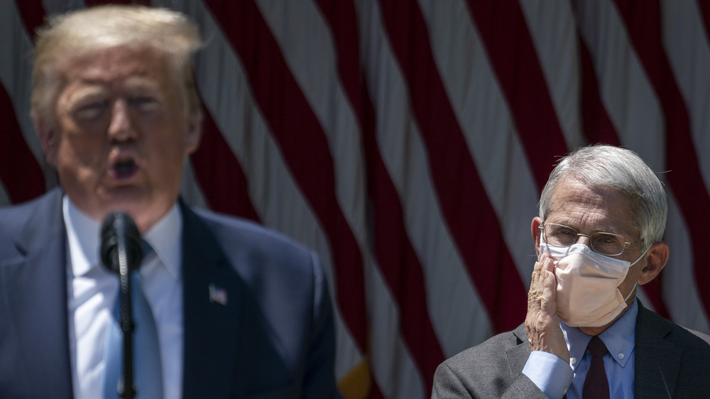 Dr. Fauci looks on as Donald Trump gives an impassioned speech