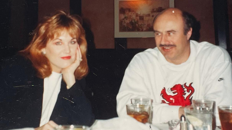 Dr. Phil McGraw and Robin McGraw sitting at a dinner table (est. 1990s)