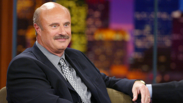 Dr. Phil McGraw sitting in chair on a talk show