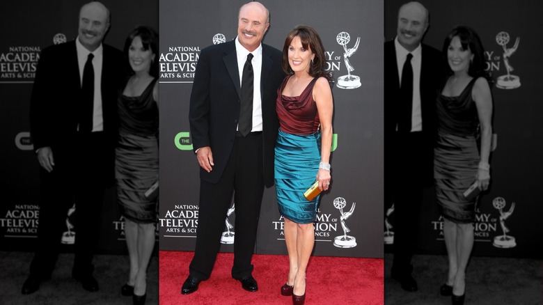 Phil McGraw and Robin McGraw smiling on the red carpet at the Emmys