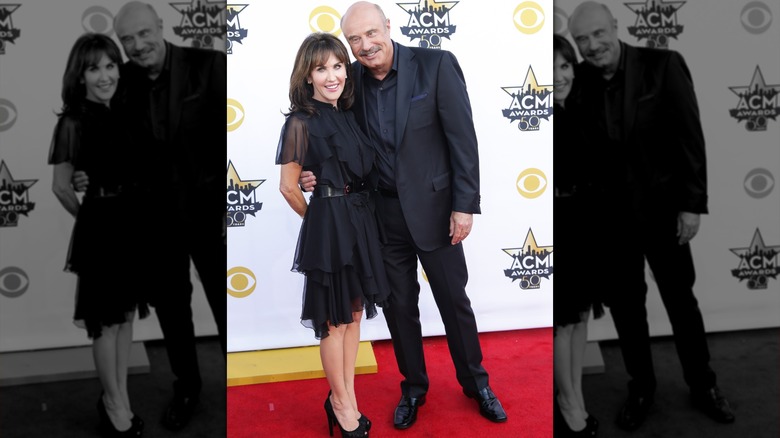 Phil McGraw with arm around Robin McGraw both smiling at the ACM Awards