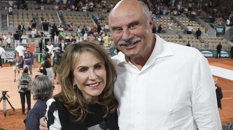 Dr. Phil and Robin McGraw smiling in a stadium in 2022.