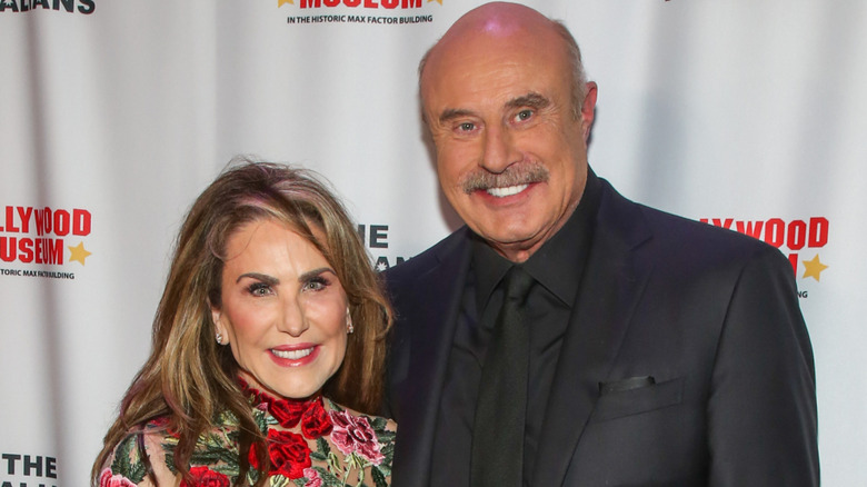 Robin and Phil McGraw smiling and embracing while posing together at an event