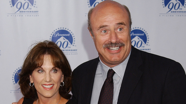 Robin and Phil McGraw smiling and embracing while posing together at an event