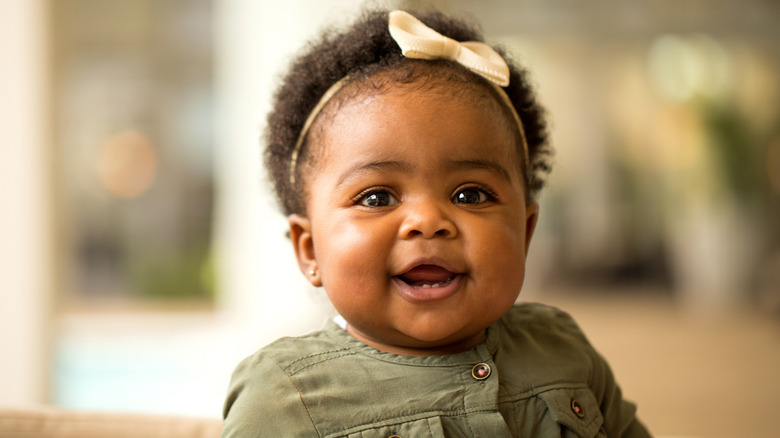 Baby wearing bow headband smiling