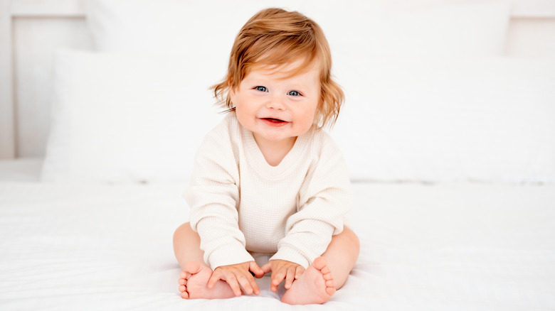 Baby smiling and holding their feet
