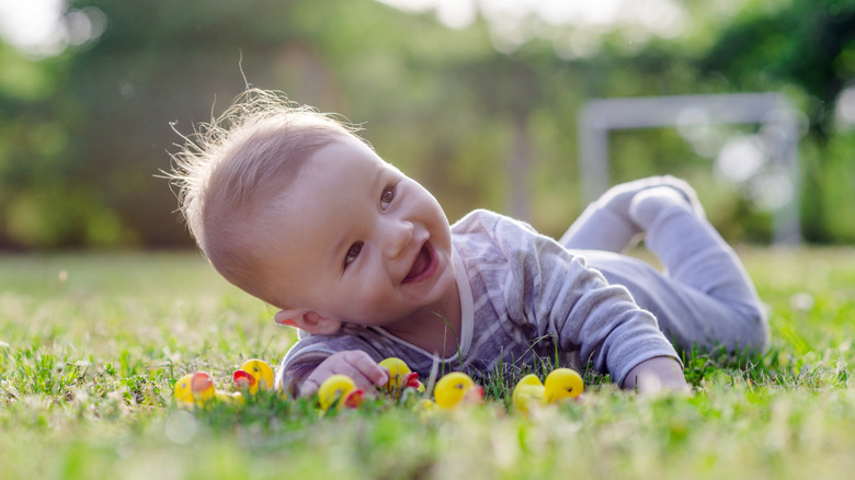Baby lying in the grass smiling
