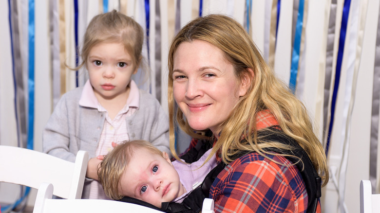 Drew Barrymore smiling at a 2014 Baby2Baby Holiday party with her daughters Olive and Frankie