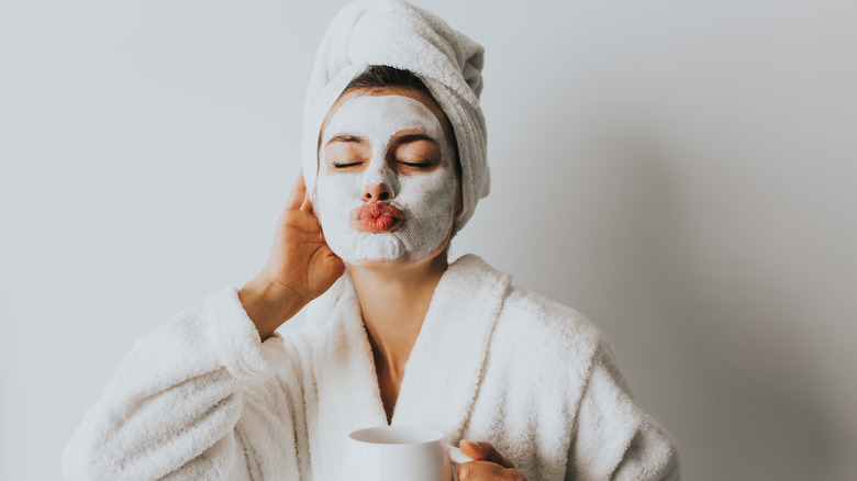 Woman with a face mask and bathrobe