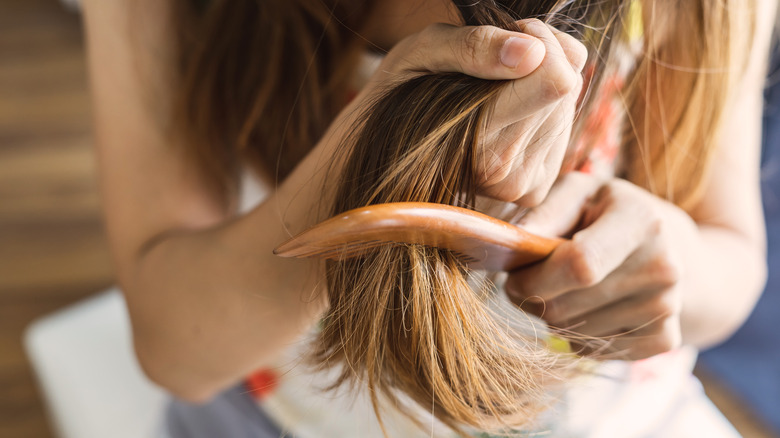 Woman struggling to brush hair