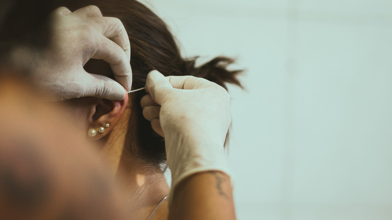woman getting an ear piercing