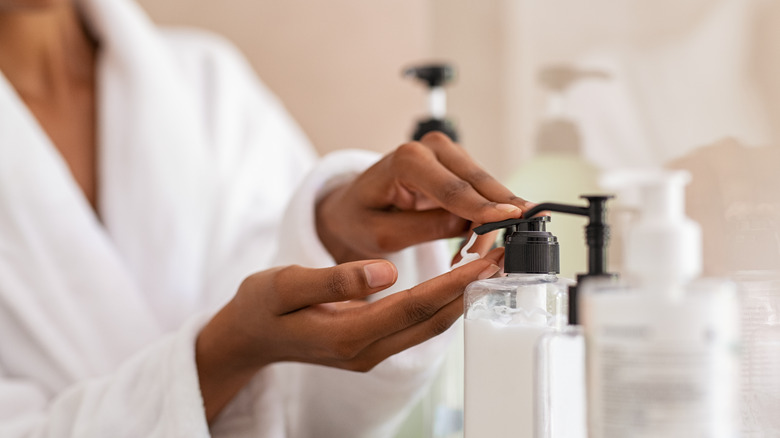 Woman putting lotion on her hands
