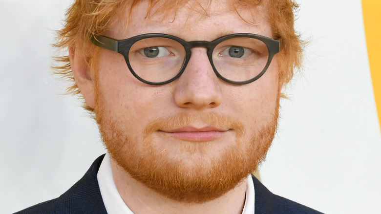 Ed Sheeran in glasses with slight smirk