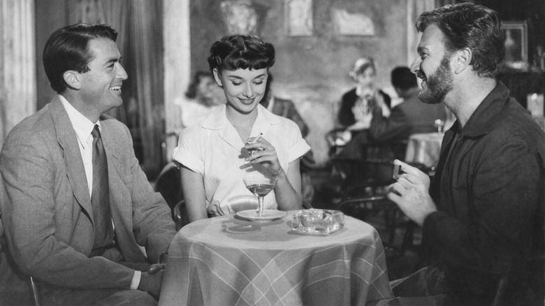 Gregory Peck, Audrey Hepburn, and Eddie Albert at a table