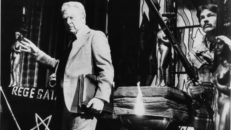 Eddie Albert holding a book and Tom Skerritt holding a weapon in The Devil's Rain