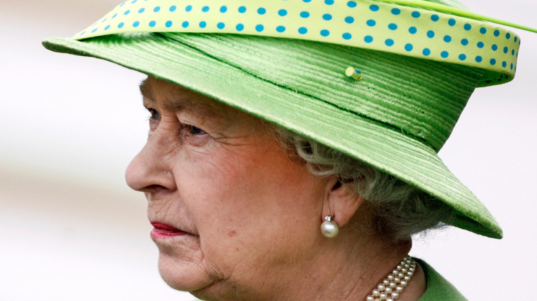 Queen Elizabeth II looks grumpy in a green hat