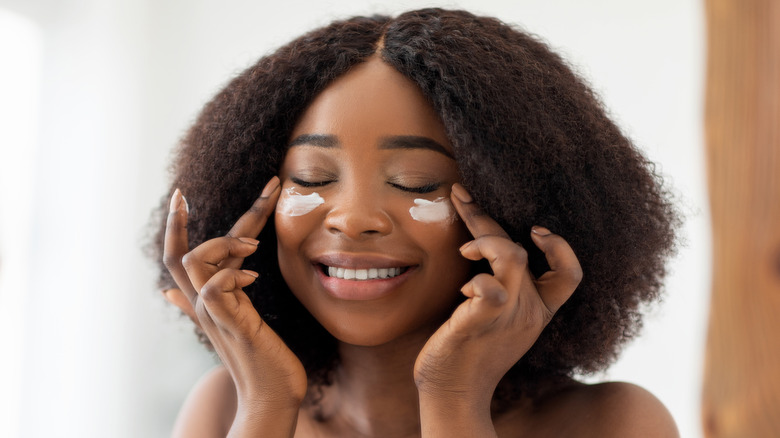 Woman applying eye cream 