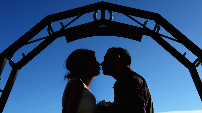 A couple getting married under the horseshoe arch at Gretna Green