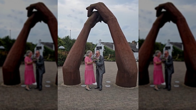 Robert Thorp, 97, and Jean Owen, 88 dance under a sculpture of two hands on their wedding day at Gretna Green.