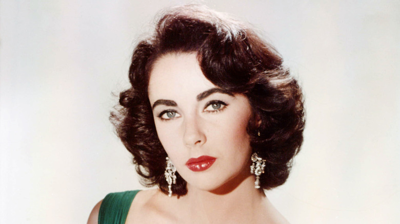 Elizabeth Taylor wearing large diamond earrings in a promo photo.