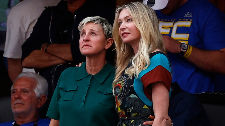 Ellen DeGeneres and Portia de Rossi standing up in a crowd