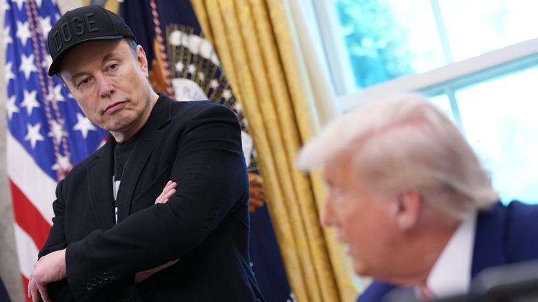 Elon Musk staring sternly at Donald Trump