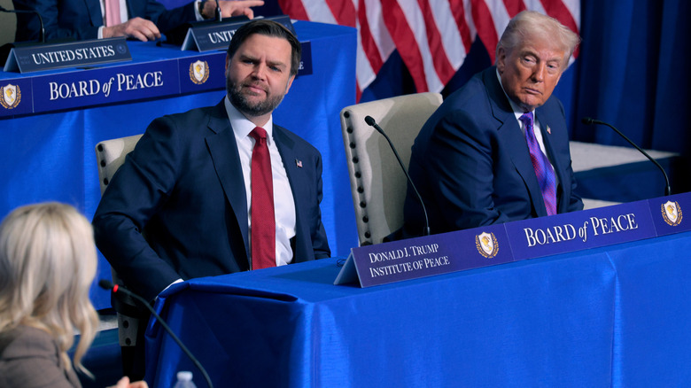 JD Vance frowning as he sits next to Donald Trump at the first Board of Peace meeting