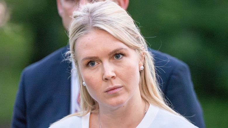 Karoline Leavitt listens to Donald Trump at a press conference in Washington, DC (2025)