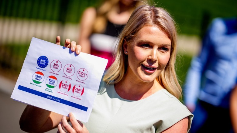 Karoline Leavitt holds up a paper about tariffs on the North Lawn of the White House (2025)