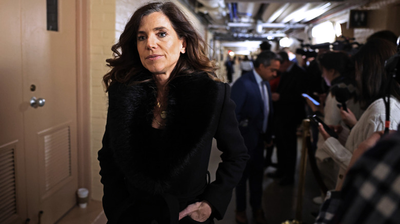 Nancy Mace walking past reporters in a black jacket with her hand in her pocket