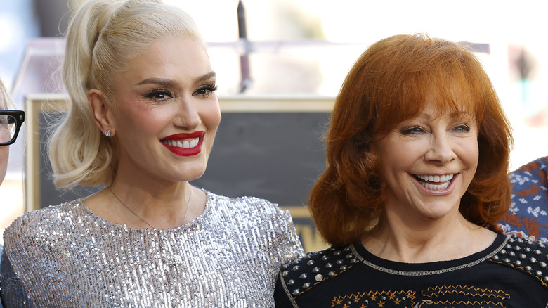 Reba McEntire with basic hair standing next to Gwen Stefani