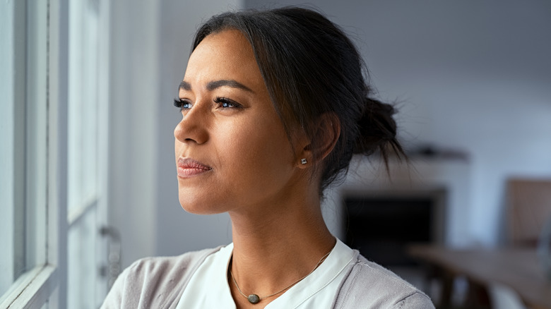 Woman looking pensively out window