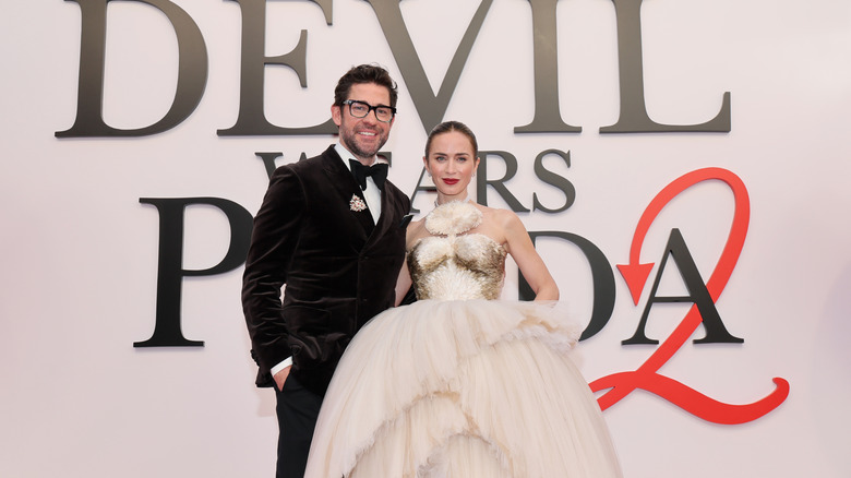 John Krasinski in a black suit and Emily Blunt in a white tulle dress