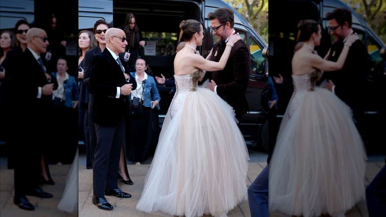 Emily Blunt wraps her arms around John Krasinski, while Stanley Tucci (far-left) looks on