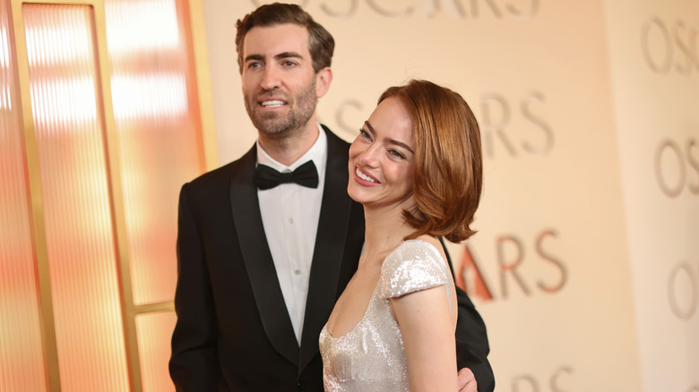 Emma Stone and her husband Dave McCary smile for cameras on the red carpet