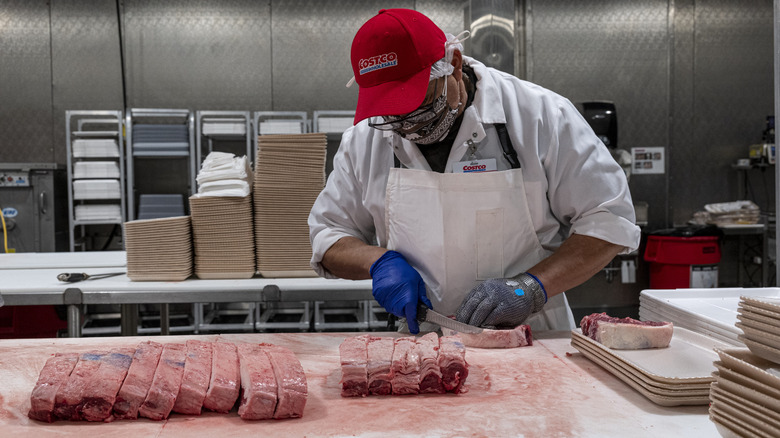 A Costco working carving meat 