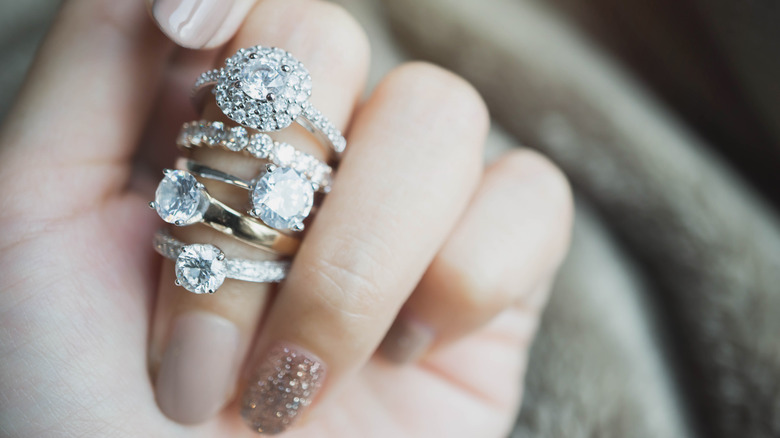 stacks of engagement rings on a woman's hand