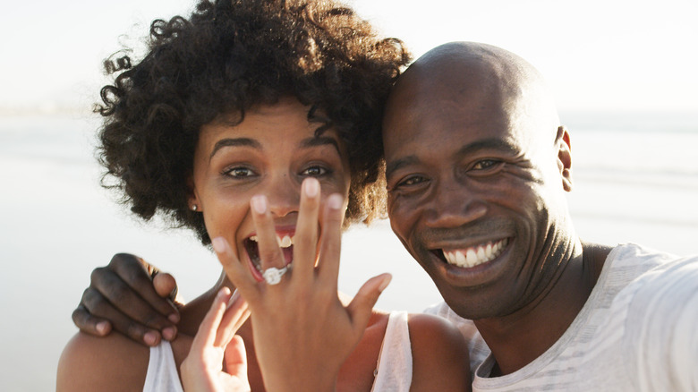 woman showing off engagement ring in selfie with fiancé