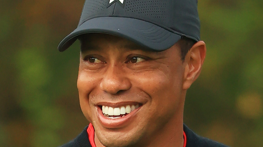 Tiger Woods smiling in baseball hat