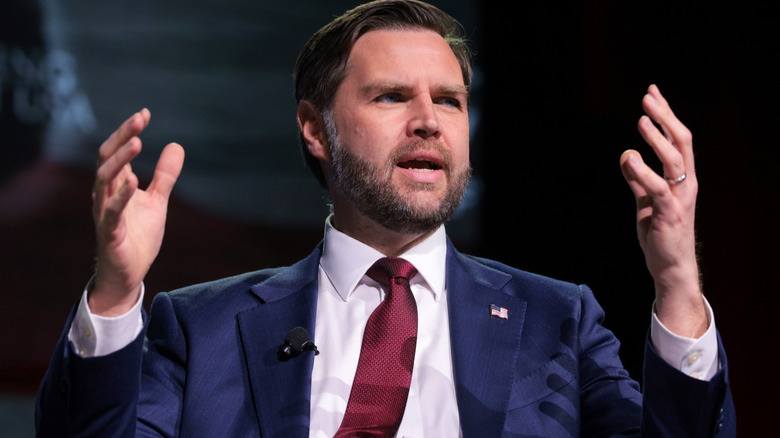 JD Vance raising his hands while speaking at a Turning Point USA event at the University of Georgia