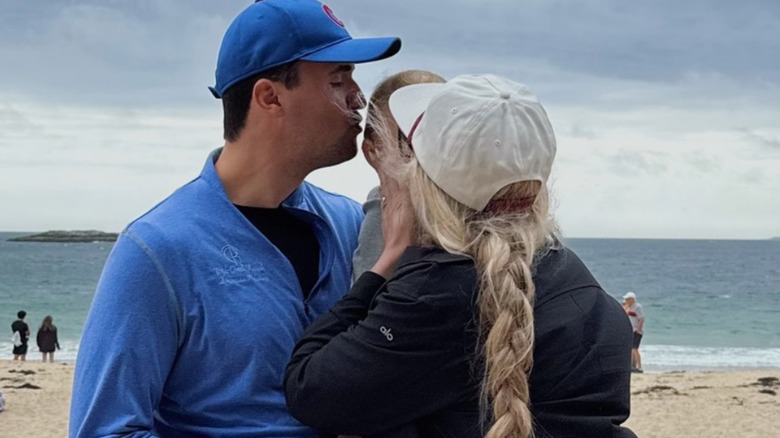 Charlie Kirk and Erika Kirk kiss their child
